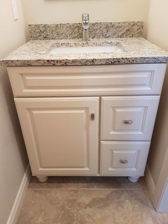 This is an example of a small traditional powder room in Calgary with raised-panel cabinets, yellow cabinets, grey walls, ceramic floors, an undermount sink and grey floor.