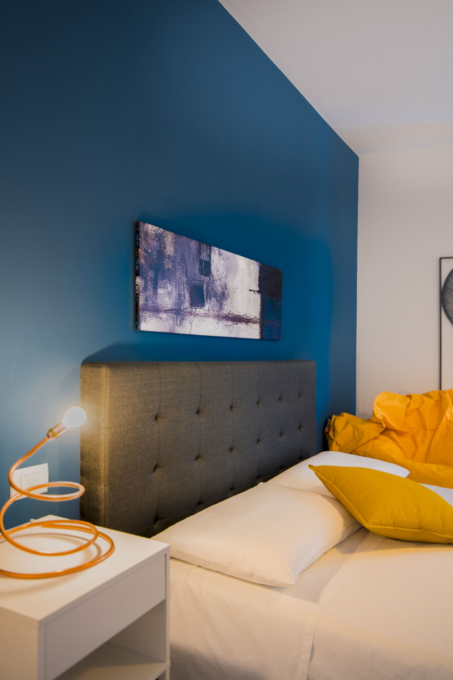 Стильный дизайн: гостевая спальня среднего размера, (комната для гостей) в стиле модернизм с синими стенами, деревянным полом и коричневым полом - последний тренд