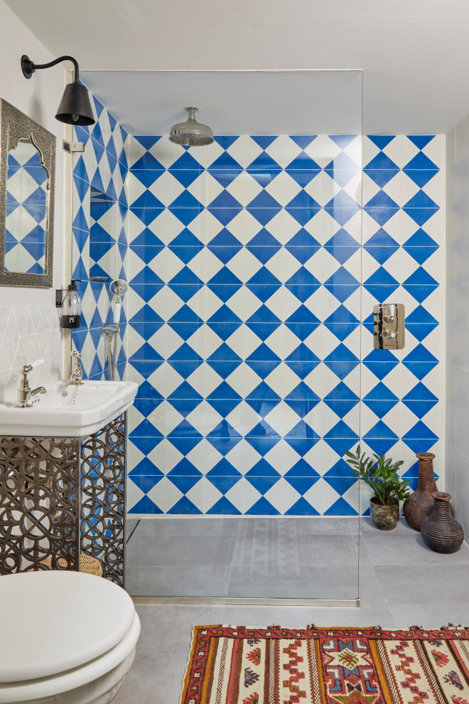 Inspiration for an eclectic bathroom in London with a curbless shower, blue tile, white tile, white walls, a console sink, grey floor, an open shower, a single vanity and a freestanding vanity.