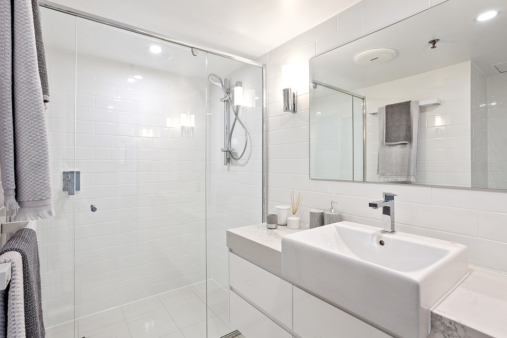 This is an example of a mid-sized contemporary master bathroom in Gold Coast - Tweed with flat-panel cabinets, light wood cabinets, a double shower, a two-piece toilet, white tile, ceramic tile, white walls, ceramic floors, a vessel sink, white floor, an open shower and quartzite benchtops.
