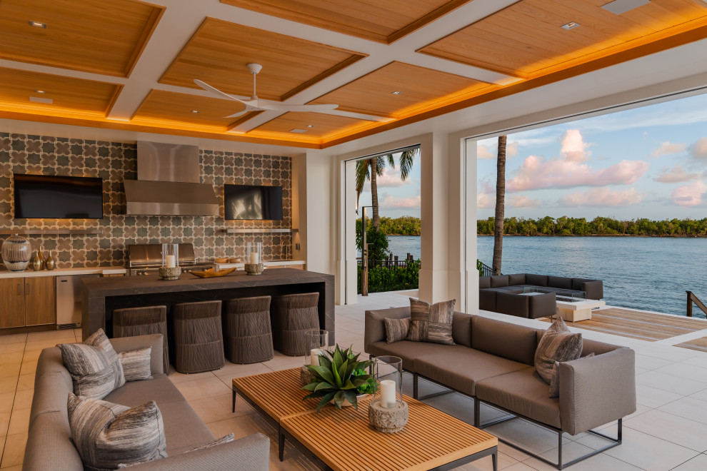 Photo of a contemporary patio in Miami with an outdoor kitchen and a roof extension.