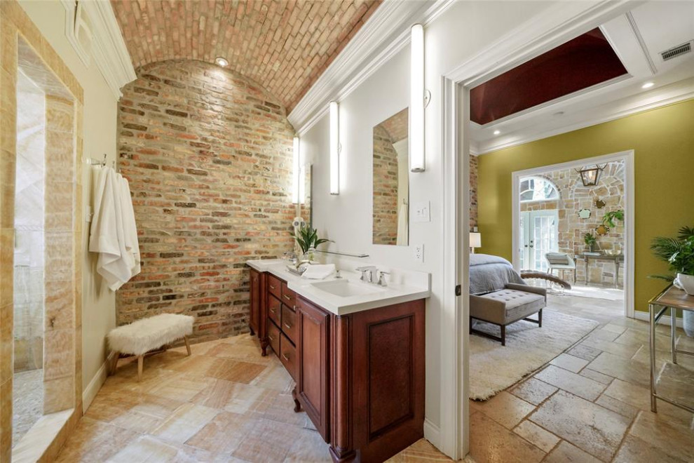 Свежая идея для дизайна: главная ванная комната в стиле фьюжн с темными деревянными фасадами, полом из травертина, тумбой под две раковины, встроенной тумбой и кирпичными стенами - отличное фото интерьера