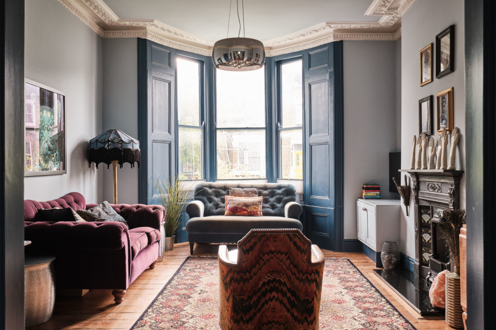 Großes, Offenes Stilmix Wohnzimmer mit blauer Wandfarbe, braunem Holzboden, Kamin, Kaminumrandung aus Metall und TV-Wand in London