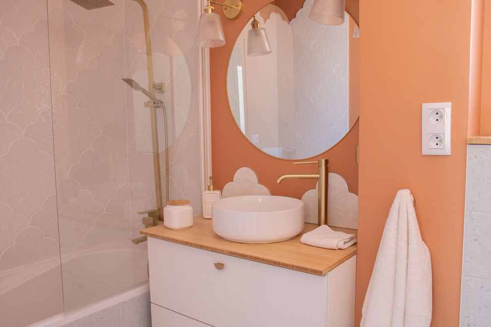 Idéer för ett litet modernt badrum för barn, med ett undermonterat badkar, en vägghängd toalettstol, vit kakel, keramikplattor, orange väggar, terrazzogolv, träbänkskiva och grått golv
