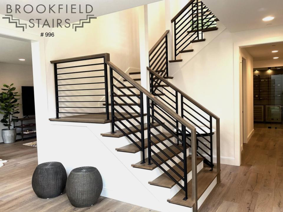This is an example of a large modern wood u-shaped staircase in Seattle with wood risers and mixed railing.