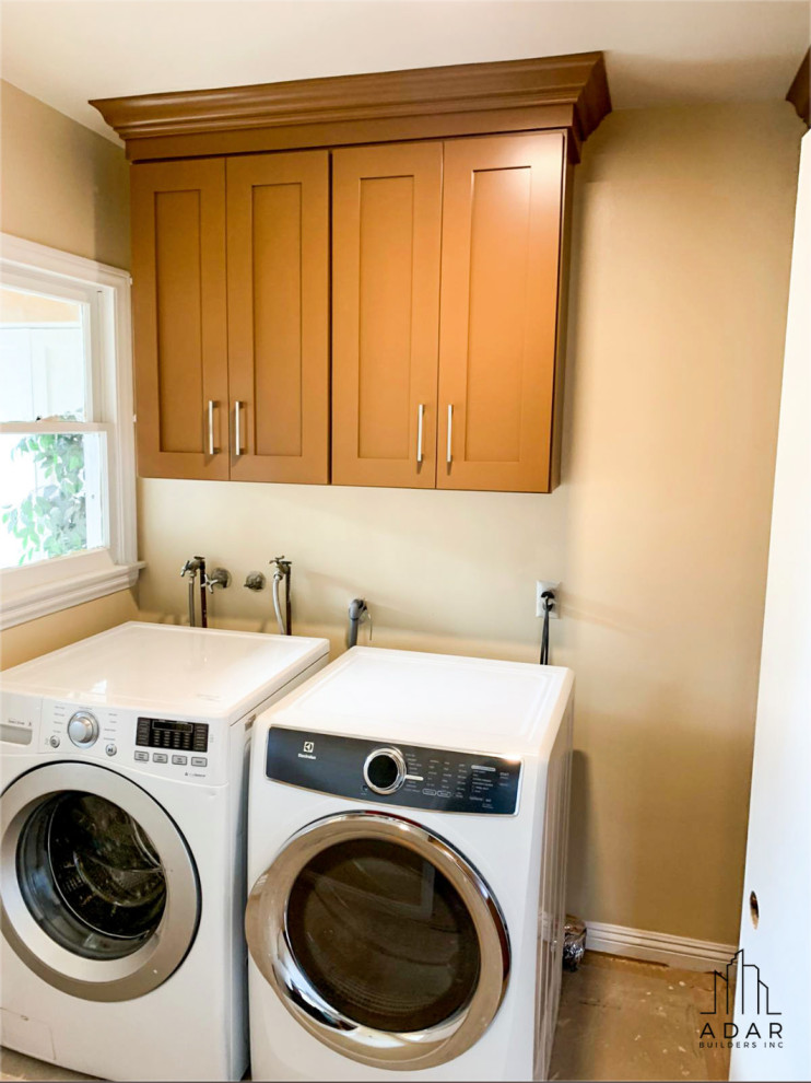 Large transitional u-shaped laundry room in Los Angeles with recessed-panel cabinets, granite benchtops, mosaic tile splashback and white benchtop.