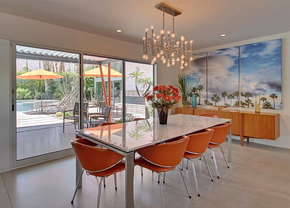 Photo of a mid-sized midcentury open plan dining in Los Angeles with white walls and concrete floors.