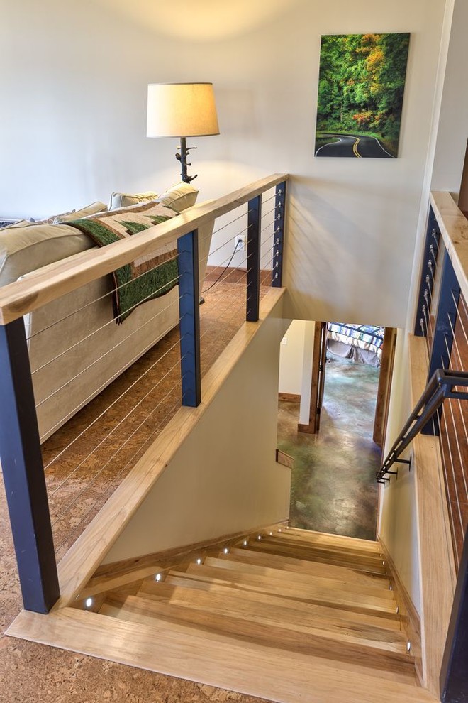 This is an example of a mid-sized arts and crafts wood straight staircase in Other with wood risers and metal railing.