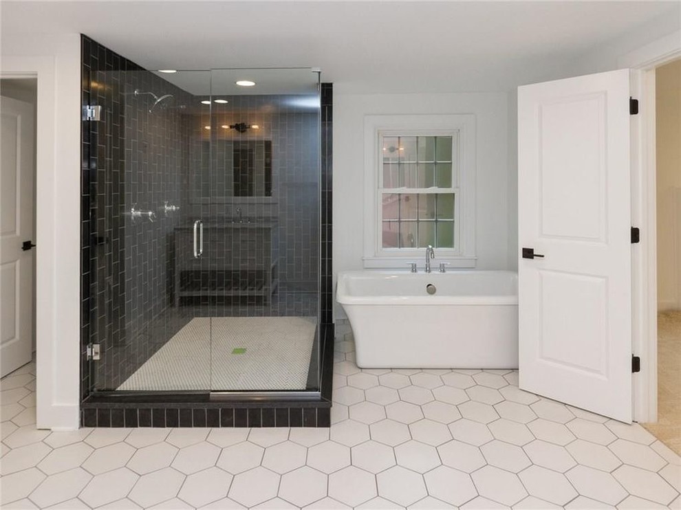 Inspiration for a contemporary master wet room bathroom in Indianapolis with flat-panel cabinets, white cabinets, a freestanding tub, a two-piece toilet, black tile, subway tile, white walls, porcelain floors, an undermount sink, granite benchtops, white floor and a hinged shower door.