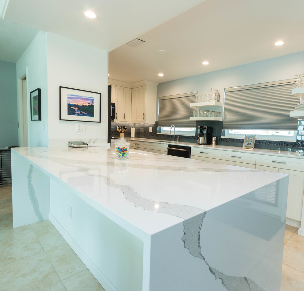 Example of a mid-sized transitional galley ceramic tile open concept kitchen design in Miami with a single-bowl sink, shaker cabinets, white cabinets, quartz countertops, black backsplash, glass tile backsplash, black appliances and a peninsula