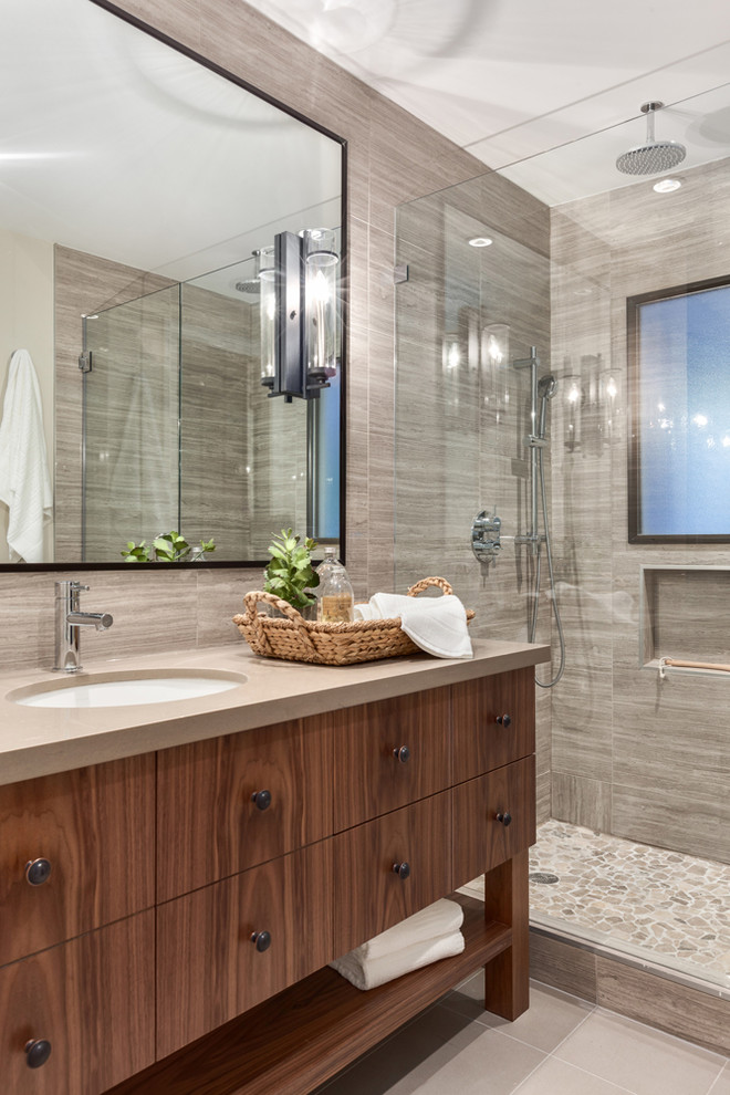 Photo of a mid-sized transitional master bathroom in Vancouver with an undermount sink, an alcove shower, gray tile, engineered quartz benchtops, stone tile, grey walls, ceramic floors, dark wood cabinets, flat-panel cabinets and a two-piece toilet.