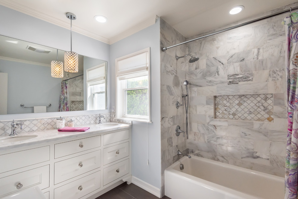 This is an example of a mid-sized transitional kids bathroom in Los Angeles with an alcove tub, a shower/bathtub combo, white tile, marble, an undermount sink, marble benchtops, a shower curtain and white benchtops.