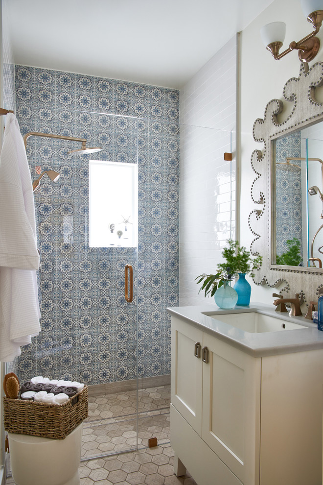 Inspiration for a mid-sized traditional 3/4 bathroom in Los Angeles with shaker cabinets, yellow cabinets, an alcove shower, blue tile, white tile, cement tile, white walls, ceramic floors, an undermount sink, solid surface benchtops, beige floor and a hinged shower door.