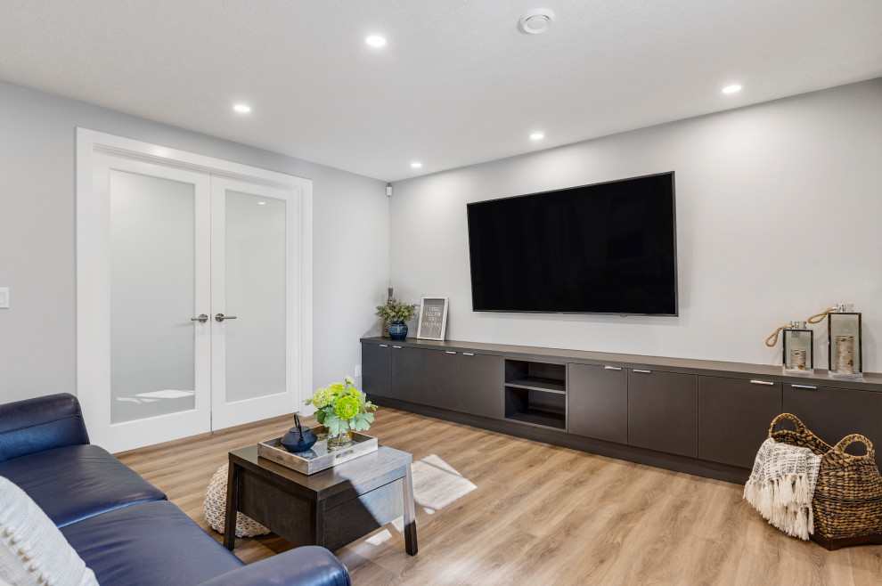 Photo of a mid-sized contemporary fully buried basement in Calgary with grey walls, vinyl floors, a standard fireplace, a tile fireplace surround and brown floor.