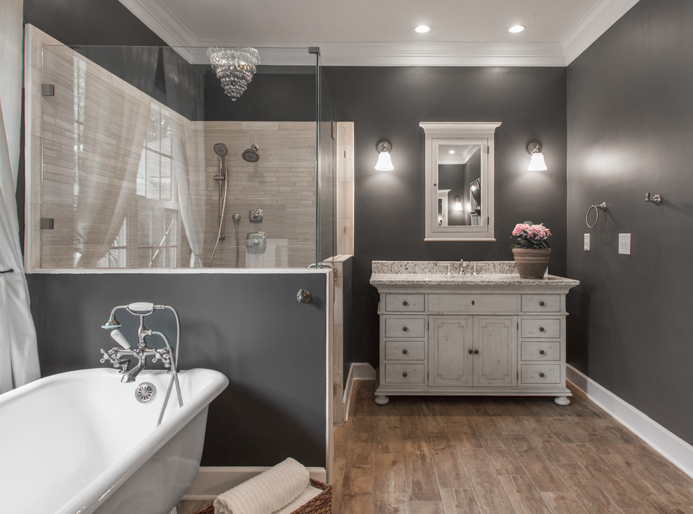 Traditional master bathroom in Jacksonville with an undermount sink, a claw-foot tub, a corner shower, grey walls, beige tile, porcelain floors, porcelain tile, distressed cabinets, granite benchtops and flat-panel cabinets.