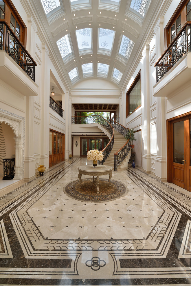 Design ideas for a large traditional entryway in Delhi with white walls and brown floor.