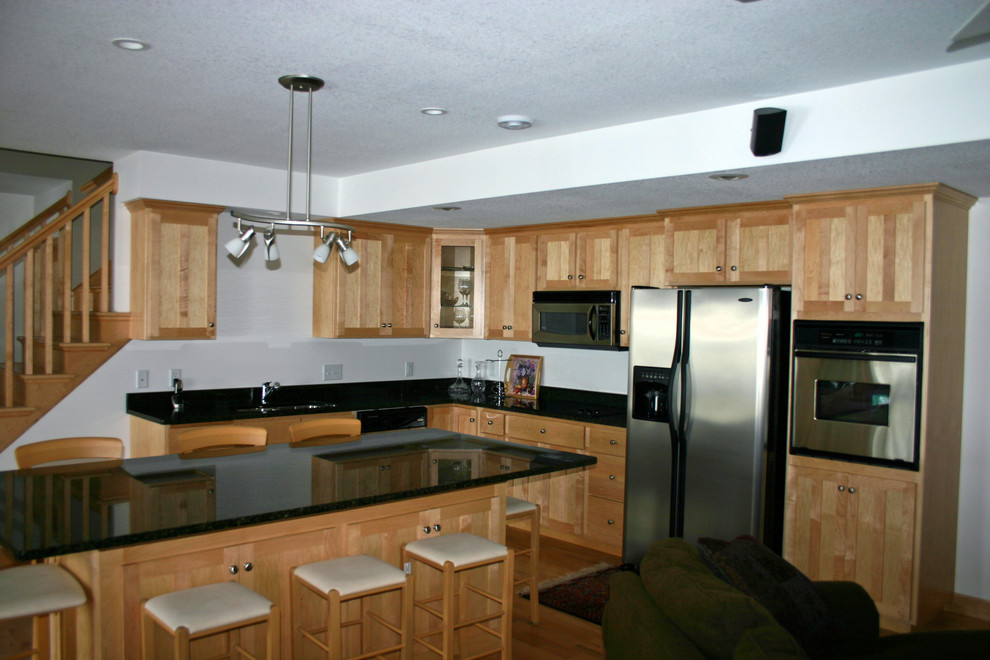 Large traditional kitchen in Minneapolis with light wood cabinets, stainless steel appliances and with island.
