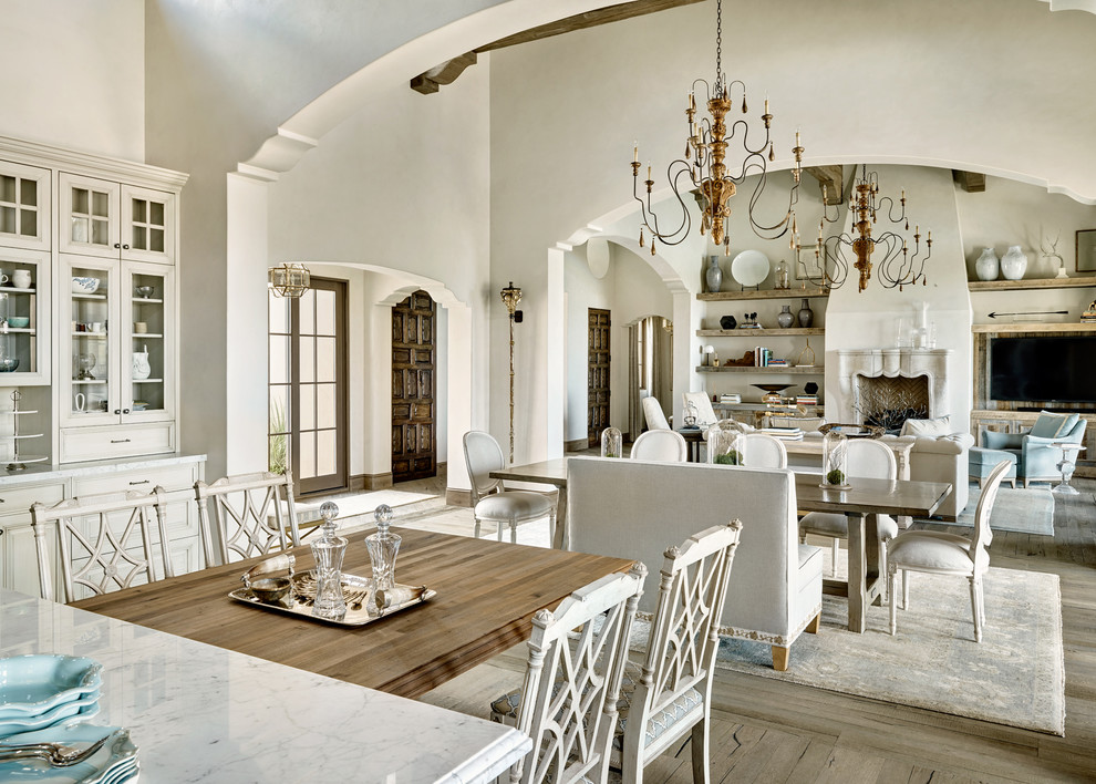 This is an example of a mediterranean open plan dining in Los Angeles with white walls and medium hardwood floors.
