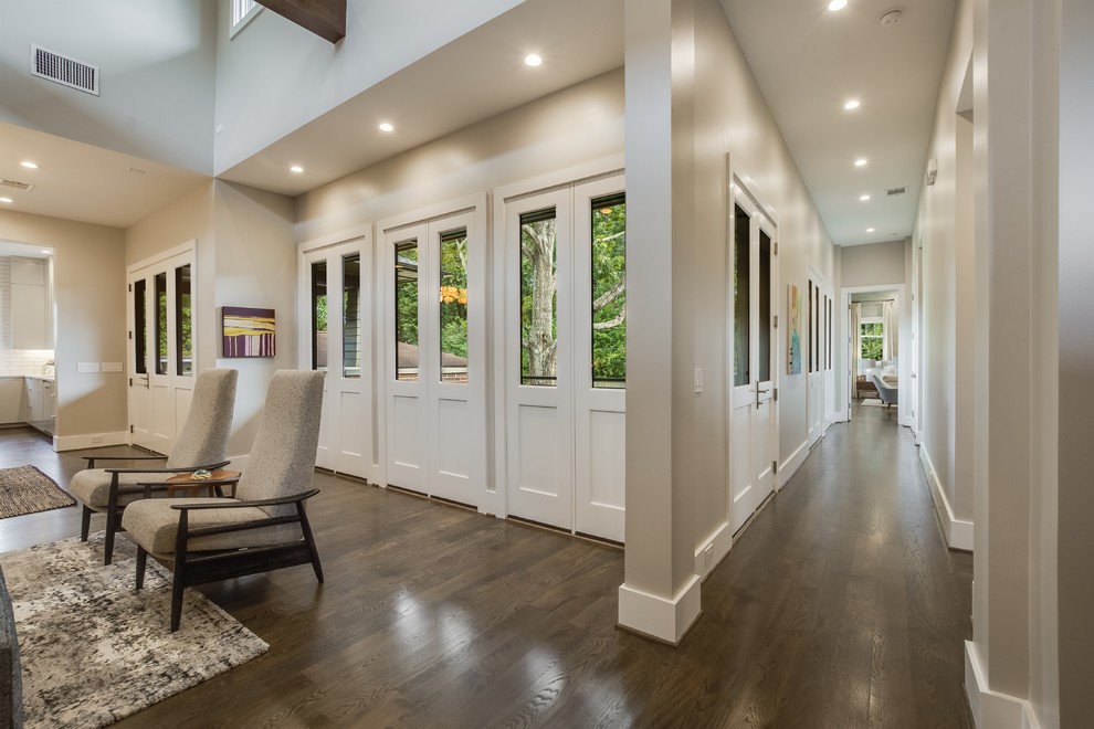 Mid-sized midcentury hallway with white walls, medium hardwood floors and brown floor.