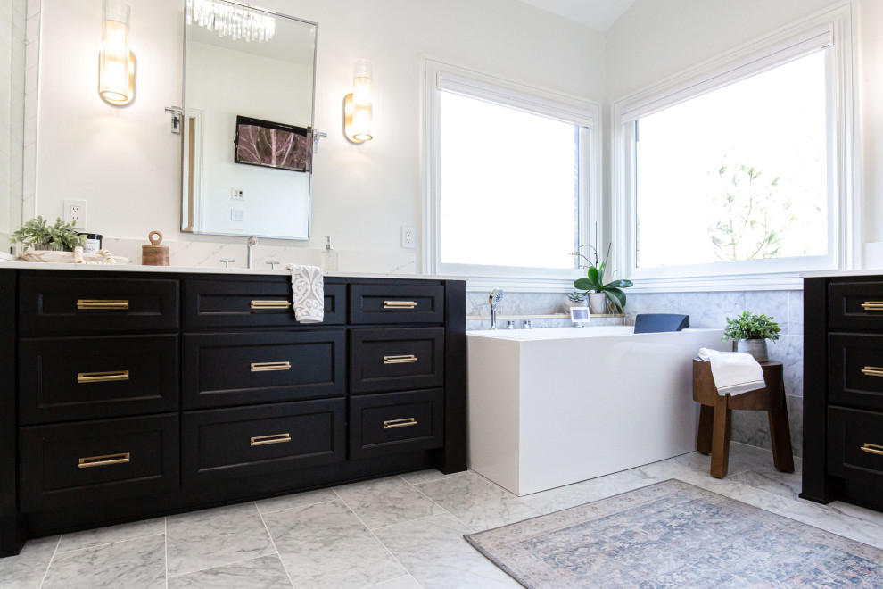 This is an example of a large contemporary ensuite bathroom in Atlanta with shaker cabinets, black cabinets, a freestanding bath, a one-piece toilet, white tiles, glass tiles, white walls, marble flooring, a submerged sink, engineered stone worktops, multi-coloured floors, a hinged door, white worktops, a wall niche, a single sink, a freestanding vanity unit and a vaulted ceiling.