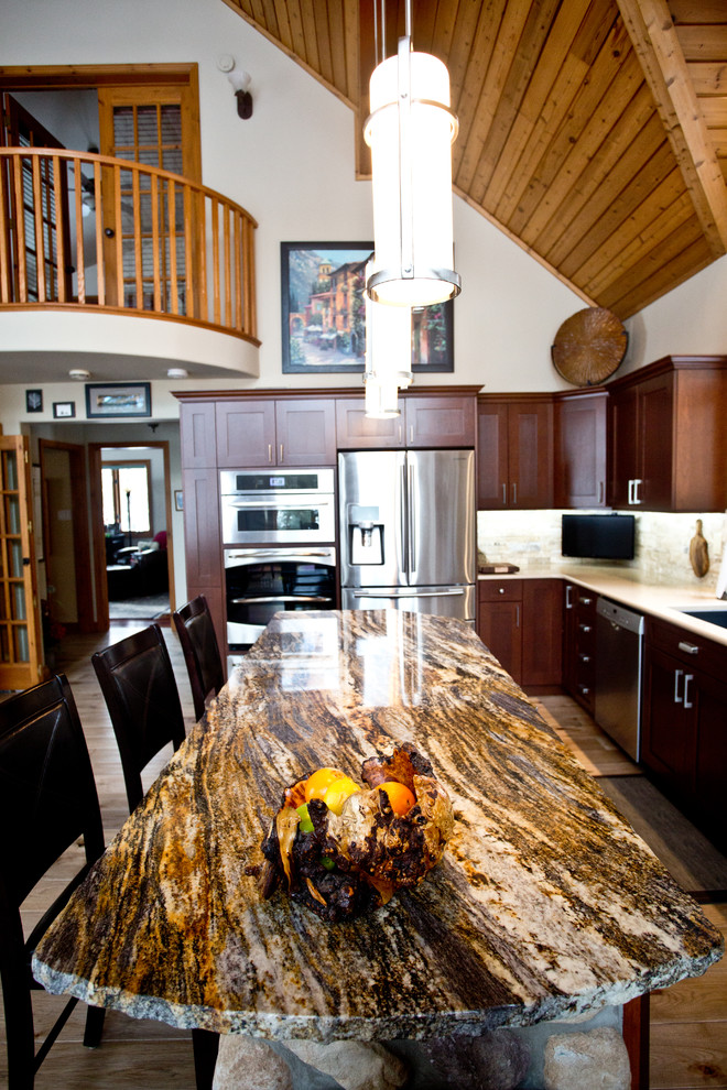 Eat-in kitchen - large rustic l-shaped light wood floor and beige floor eat-in kitchen idea in Toronto with shaker cabinets, dark wood cabinets, granite countertops, beige backsplash, stainless steel appliances, an island, an undermount sink and stone tile backsplash