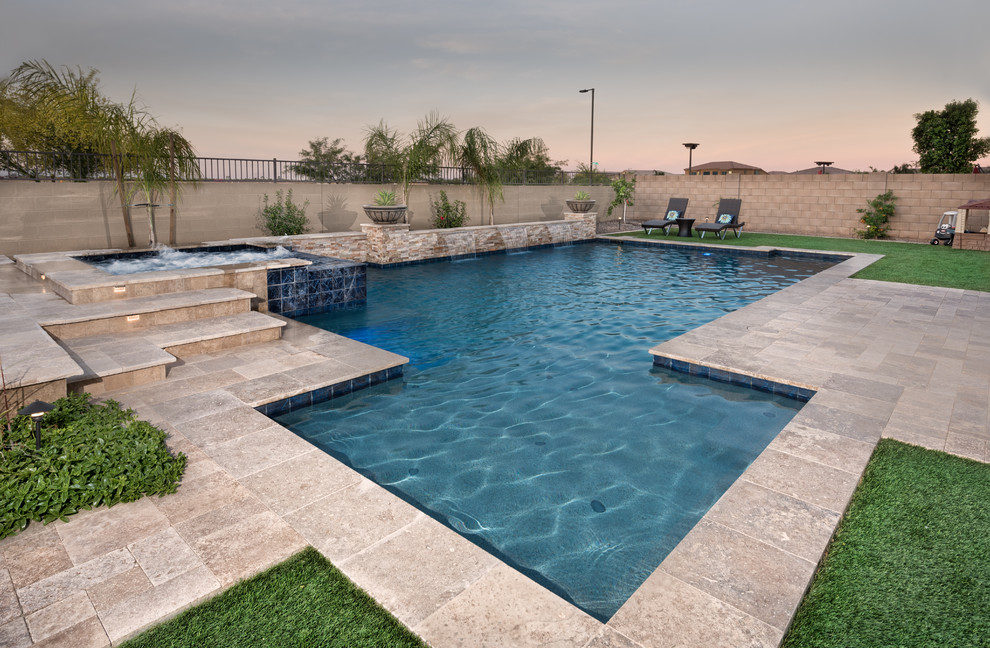 Photo of a large contemporary backyard custom-shaped pool in Phoenix with a hot tub and natural stone pavers.