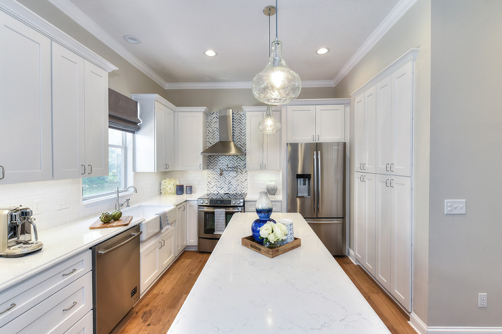Inspiration for a large transitional l-shaped medium tone wood floor eat-in kitchen remodel in Jacksonville with a farmhouse sink, shaker cabinets, quartz countertops and an island