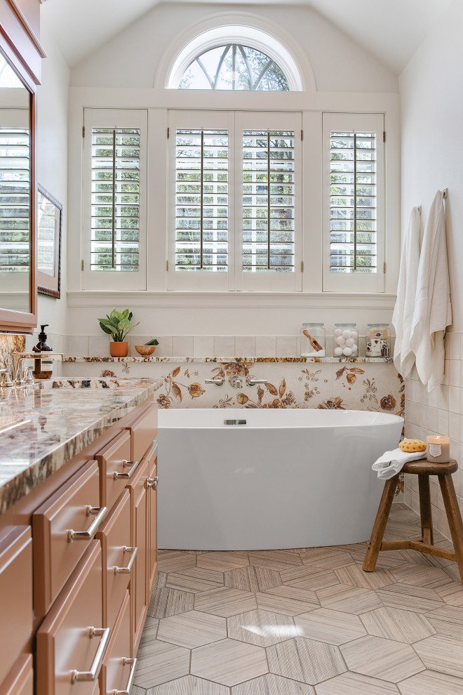 Bild på ett stort eklektiskt flerfärgad flerfärgat en-suite badrum, med luckor med upphöjd panel, bruna skåp, ett fristående badkar, en dusch i en alkov, en toalettstol med hel cisternkåpa, flerfärgad kakel, keramikplattor, vita väggar, klinkergolv i porslin, ett nedsänkt handfat, granitbänkskiva, grått golv och dusch med gångjärnsdörr