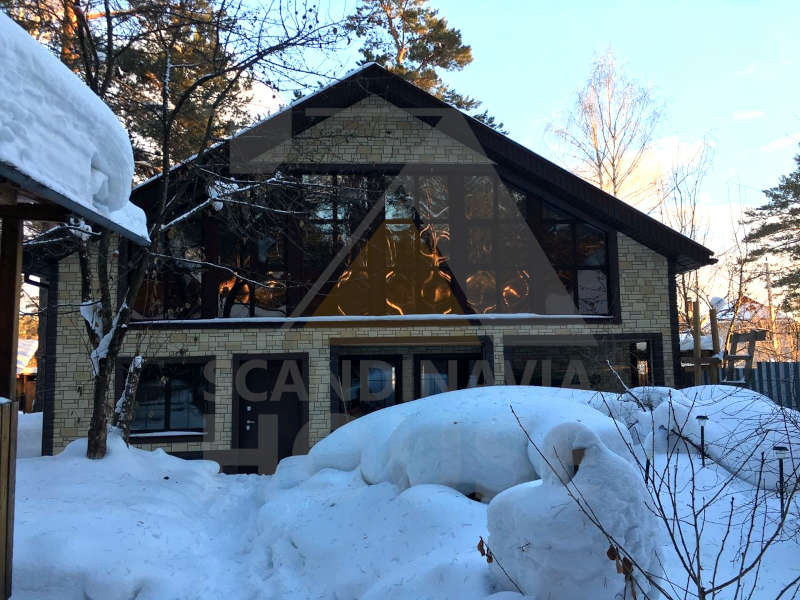 На фото: большой, двухэтажный частный загородный дом в скандинавском стиле с облицовкой из металла, двускатной крышей и коричневой крышей