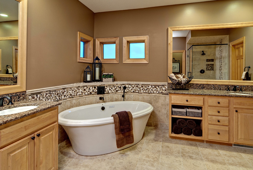 This is an example of a contemporary bathroom in Minneapolis with granite benchtops and a freestanding tub.