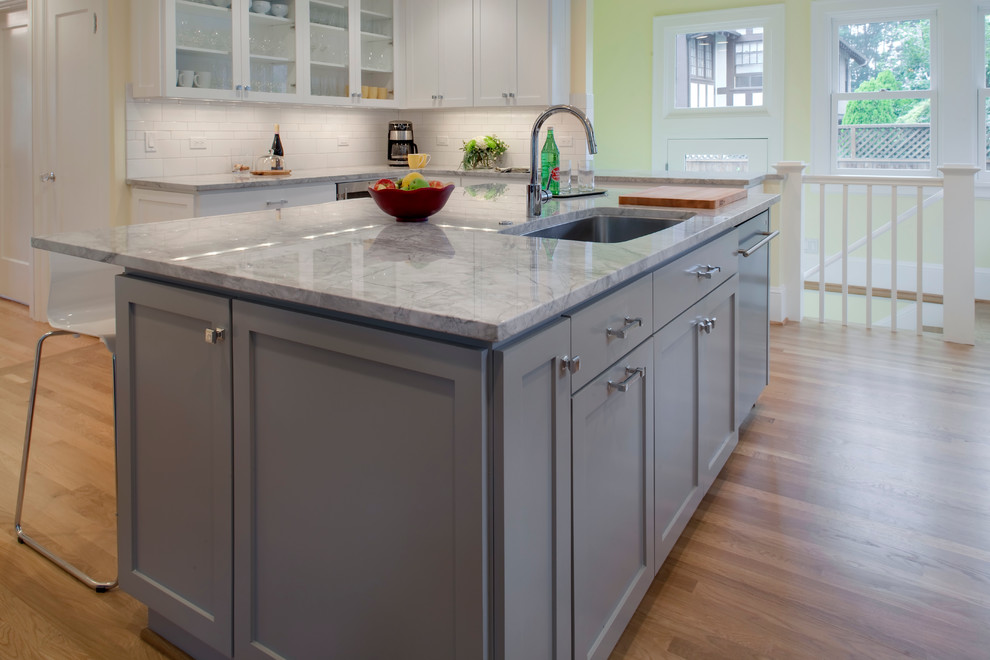 Inspiration for a mid-sized arts and crafts u-shaped eat-in kitchen in Portland with an undermount sink, shaker cabinets, grey cabinets, quartzite benchtops, white splashback, subway tile splashback, stainless steel appliances, medium hardwood floors and with island.