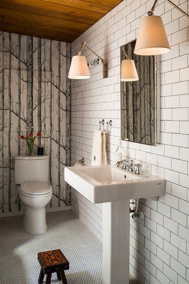 This is an example of a transitional powder room in Charlotte with white tile, subway tile, multi-coloured walls, a pedestal sink and white floor.