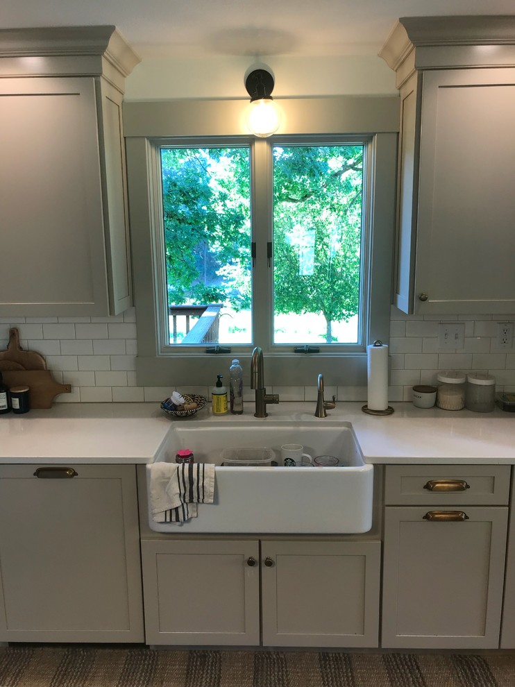 Eat-in kitchen - large transitional galley dark wood floor and brown floor eat-in kitchen idea in Chicago with a farmhouse sink, shaker cabinets, beige cabinets, quartz countertops, white backsplash, subway tile backsplash, stainless steel appliances, an island and white countertops