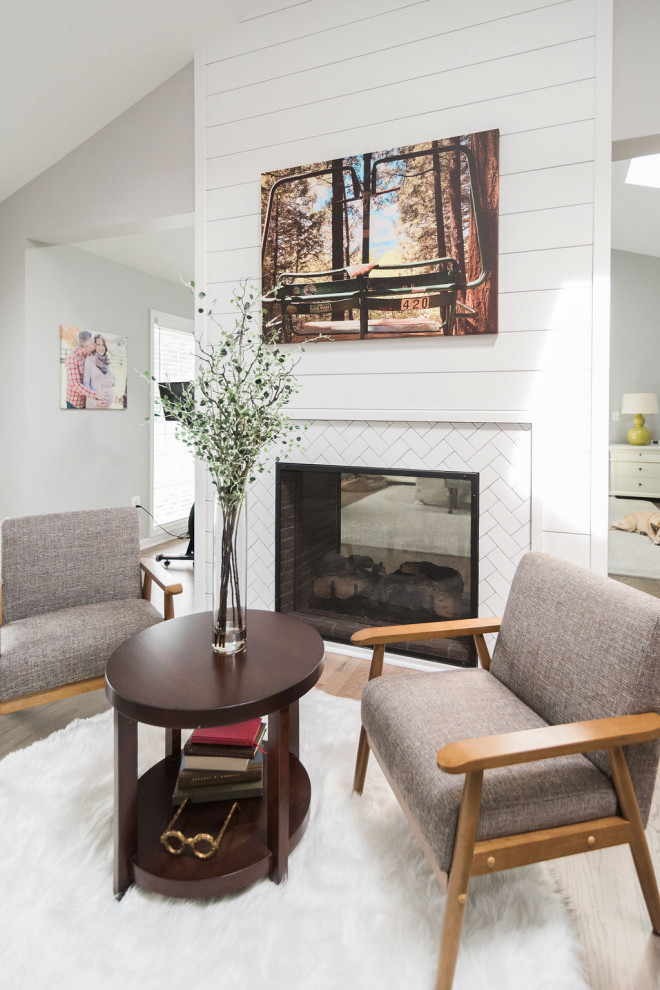 Large elegant master medium tone wood floor, brown floor, vaulted ceiling and shiplap wall bedroom photo in Baltimore with gray walls, a two-sided fireplace and a tile fireplace