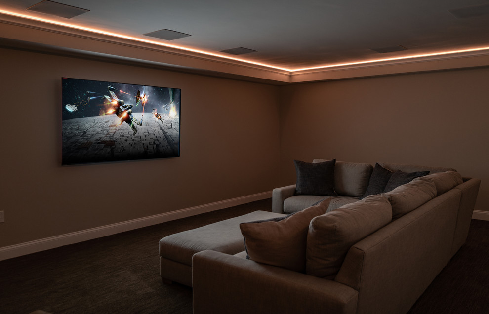 Imagen de cine en casa cerrado tradicional renovado grande con paredes grises, moqueta, televisor colgado en la pared y suelo gris