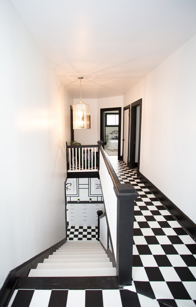 Example of a mid-sized transitional vinyl floor and black floor hallway design with white walls