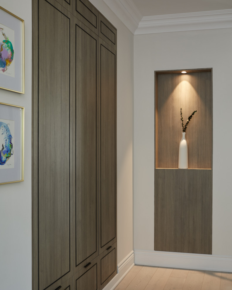 Mid-sized contemporary hallway in Toronto with white walls, light hardwood floors, beige floor and wood walls.