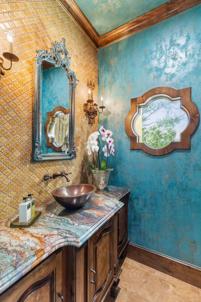 Inspiration for a medium sized cloakroom in Houston with raised-panel cabinets, brown cabinets, a two-piece toilet, yellow tiles, porcelain tiles, blue walls, travertine flooring, a vessel sink, granite worktops, beige floors, multi-coloured worktops and a built in vanity unit.
