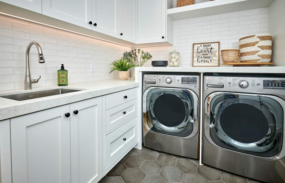 Small country l-shaped porcelain tile and gray floor dedicated laundry room photo in Denver with an undermount sink, recessed-panel cabinets, white cabinets, quartz countertops, subway tile backsplash, beige walls, a side-by-side washer/dryer and white countertops