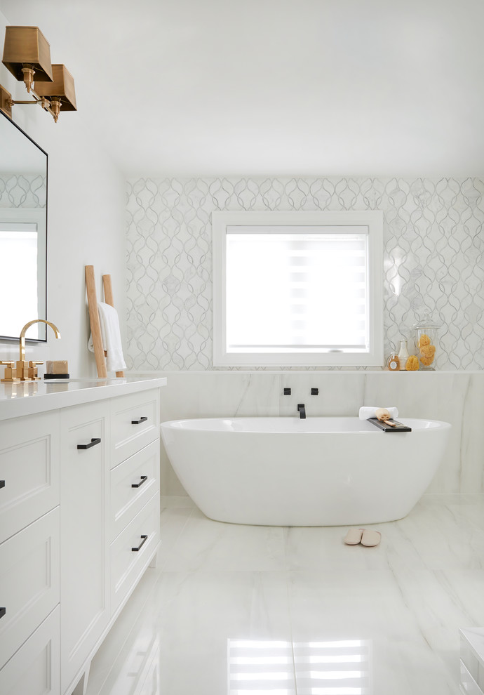 Mid-sized transitional master white floor freestanding bathtub photo in Toronto with recessed-panel cabinets, white cabinets, white walls, an undermount sink, quartz countertops and white countertops