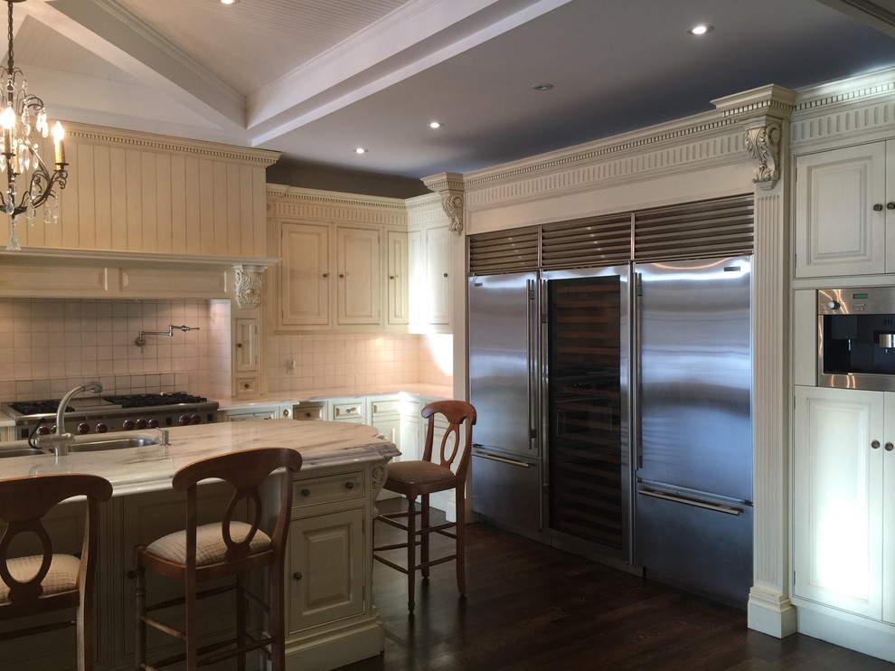 Large transitional l-shaped dark wood floor open concept kitchen photo in Toronto with a double-bowl sink, raised-panel cabinets, beige cabinets, white backsplash, stainless steel appliances and an island