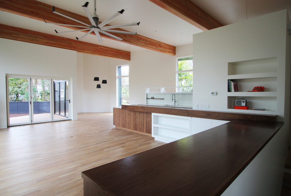 Ispirazione per un soggiorno design di medie dimensioni e aperto con pareti bianche e pavimento in legno massello medio