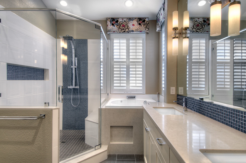 This is an example of a mid-sized transitional master bathroom in San Francisco with recessed-panel cabinets, beige cabinets, a japanese tub, a corner shower, glass tile, beige walls, ceramic floors, an undermount sink, quartzite benchtops and a hinged shower door.