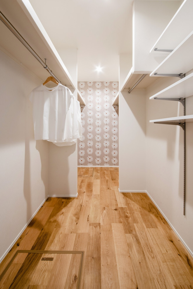 Design ideas for an asian laundry room in Other with white walls, medium hardwood floors and brown floor.