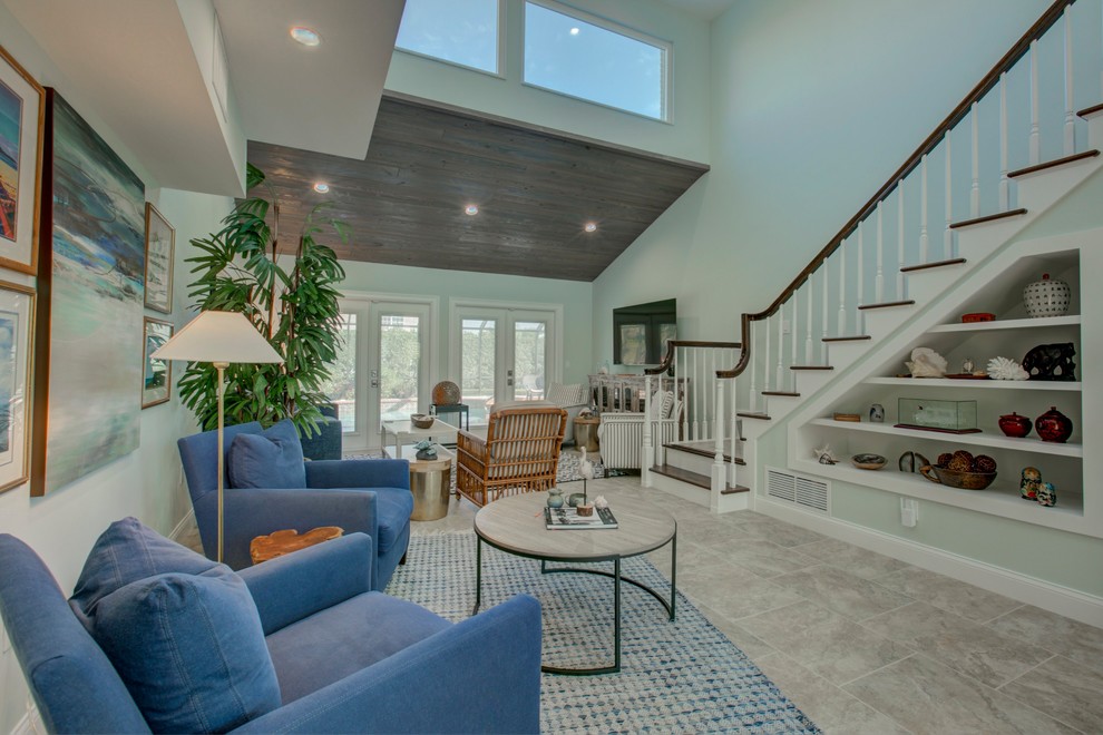 Design ideas for a large transitional formal open concept living room in Tampa with blue walls, porcelain floors, a wall-mounted tv and beige floor.
