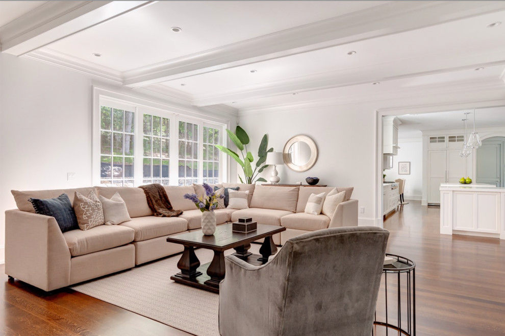 Photo of an expansive traditional open concept family room in Boston with white walls, medium hardwood floors and a wall-mounted tv.