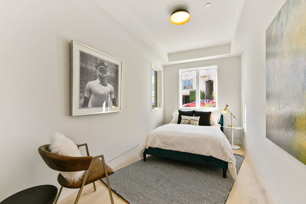 Design ideas for a small contemporary guest bedroom in San Francisco with white walls and light hardwood floors.