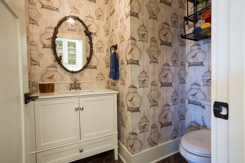 This is an example of an arts and crafts powder room in Austin with a drop-in sink, furniture-like cabinets, white cabinets, engineered quartz benchtops, a two-piece toilet, white tile, ceramic tile and vinyl floors.
