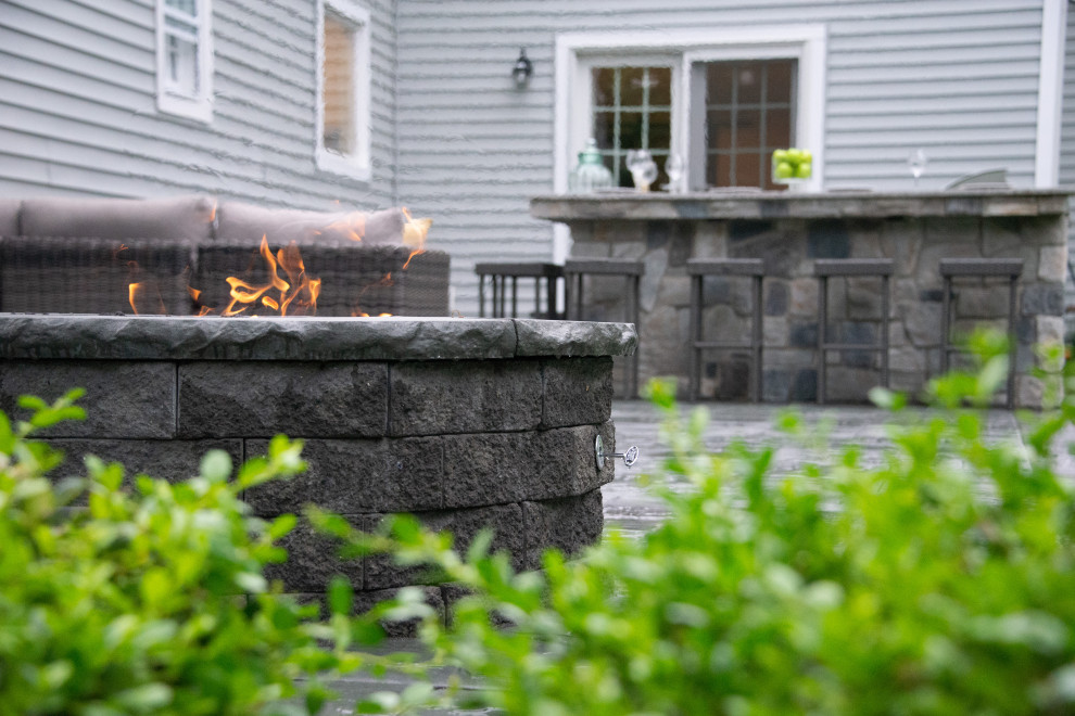 This is an example of a mid-sized modern backyard garden in Other with a fire feature and natural stone pavers.