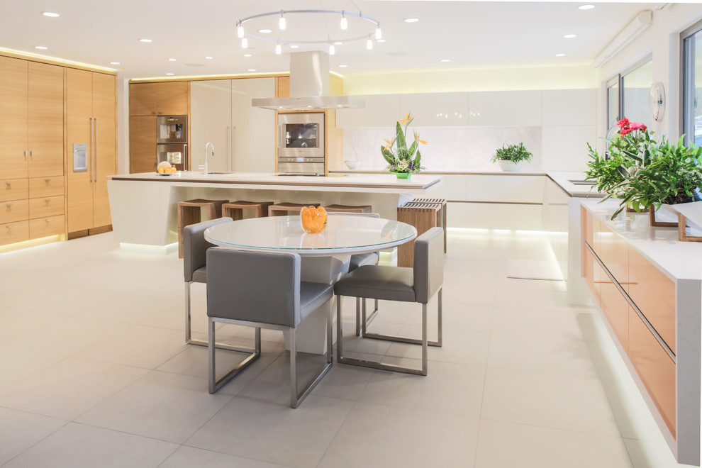 Design ideas for a large modern l-shaped open plan kitchen in Calgary with a double-bowl sink, flat-panel cabinets, white cabinets, solid surface benchtops, white splashback, stone slab splashback, panelled appliances, ceramic floors and with island.